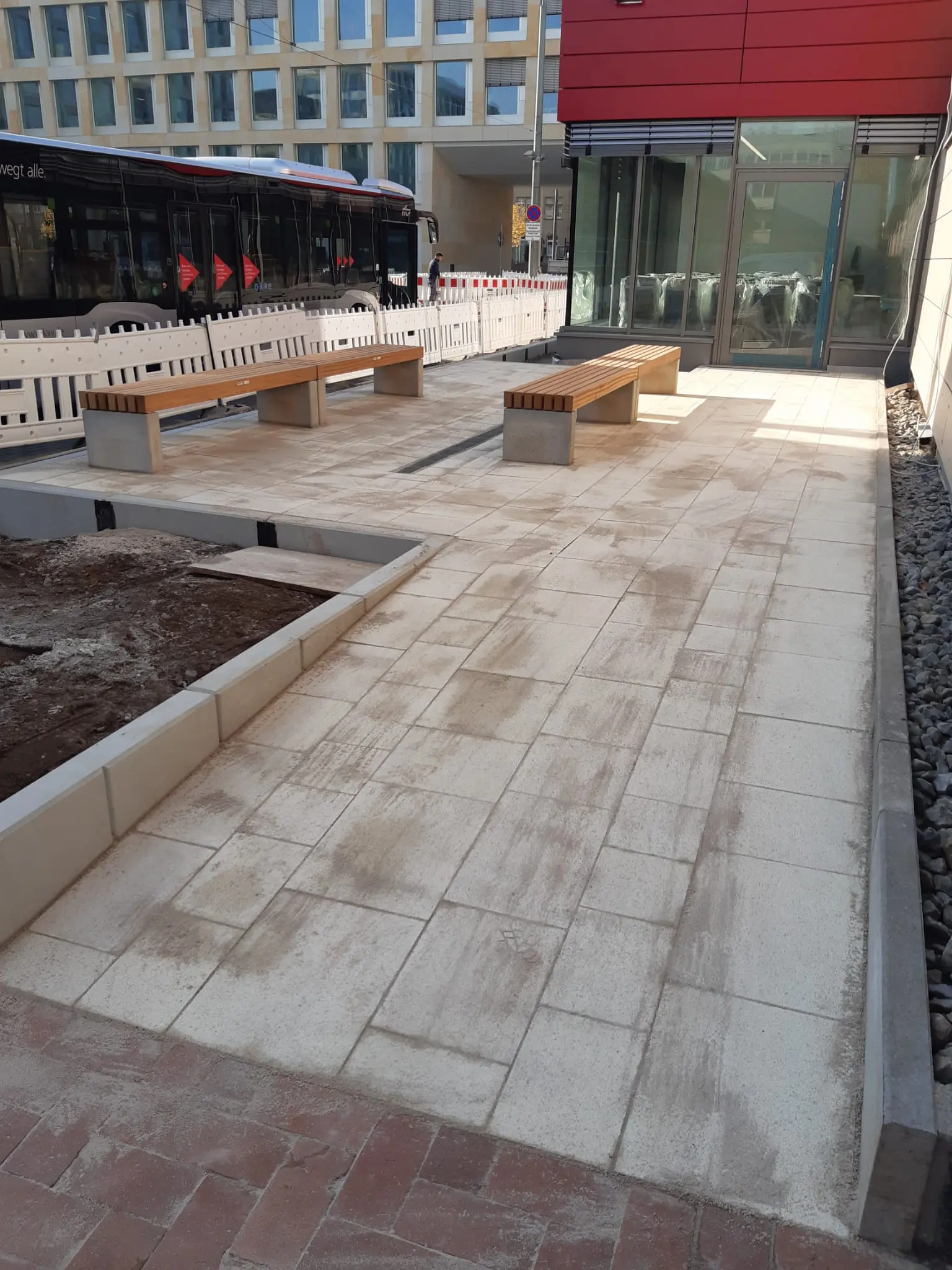 Gestaltung Aufenthaltsbereich mit Sitzbänken vor Bürogebäude und Rampe