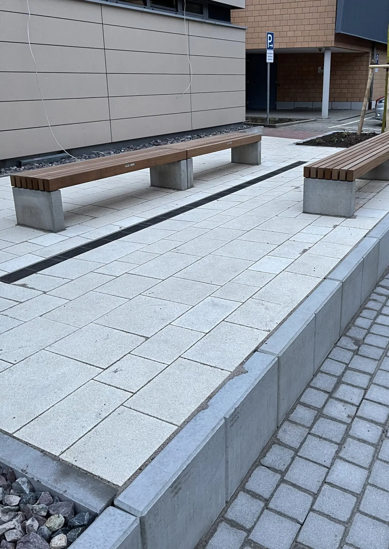 Gestaltung Aufenthaltsbereich mit Sitzbänken vor Bürogebäude