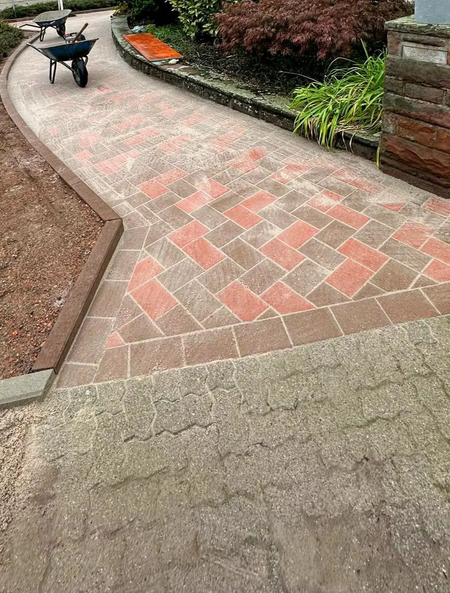 Gehweg aus Betonpflaster K4 24x16x8cm in rot und braun im Fischgrätverband verlegt