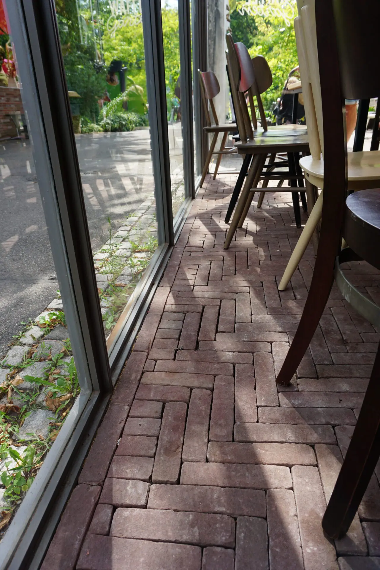 Bewirtungsraum mit Tischen und Stühlen mit Pflasterbodenbelag aus Pflasterklinkerriegel braun-bunt geflammt, antica, Maße 204x67x60mm im Fischgrätverband verlegt