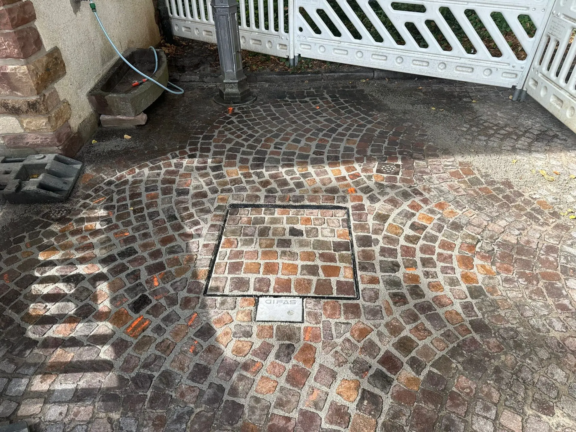 Einbau Unterflurverteiler, Anarbeitung Natursteinkleinpflaster aus Porphyr im Segmentbogen und Ausfugen mit 2k Kunstharzmörtel