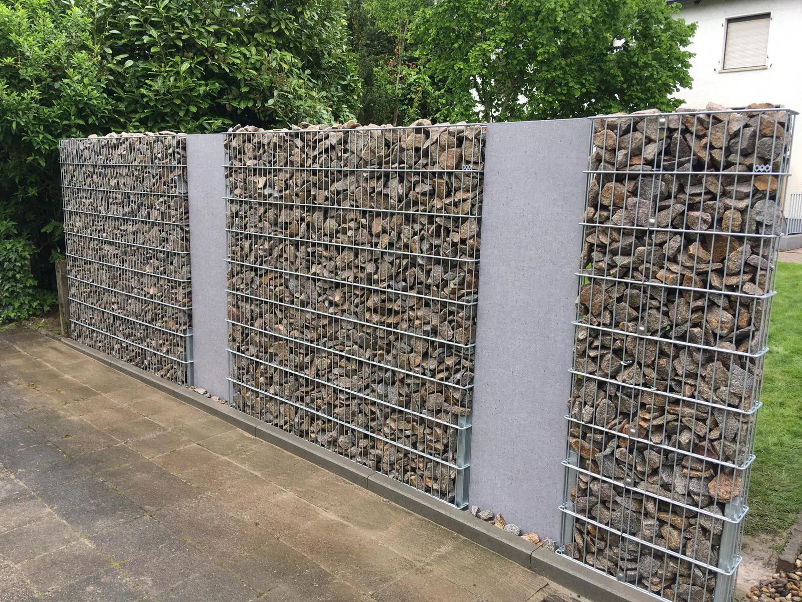 Gabionenwand 1,80m hoch mit integrierten Sichtschutzelementen aus Betonoptik, gefüllt mit Granitschroppen