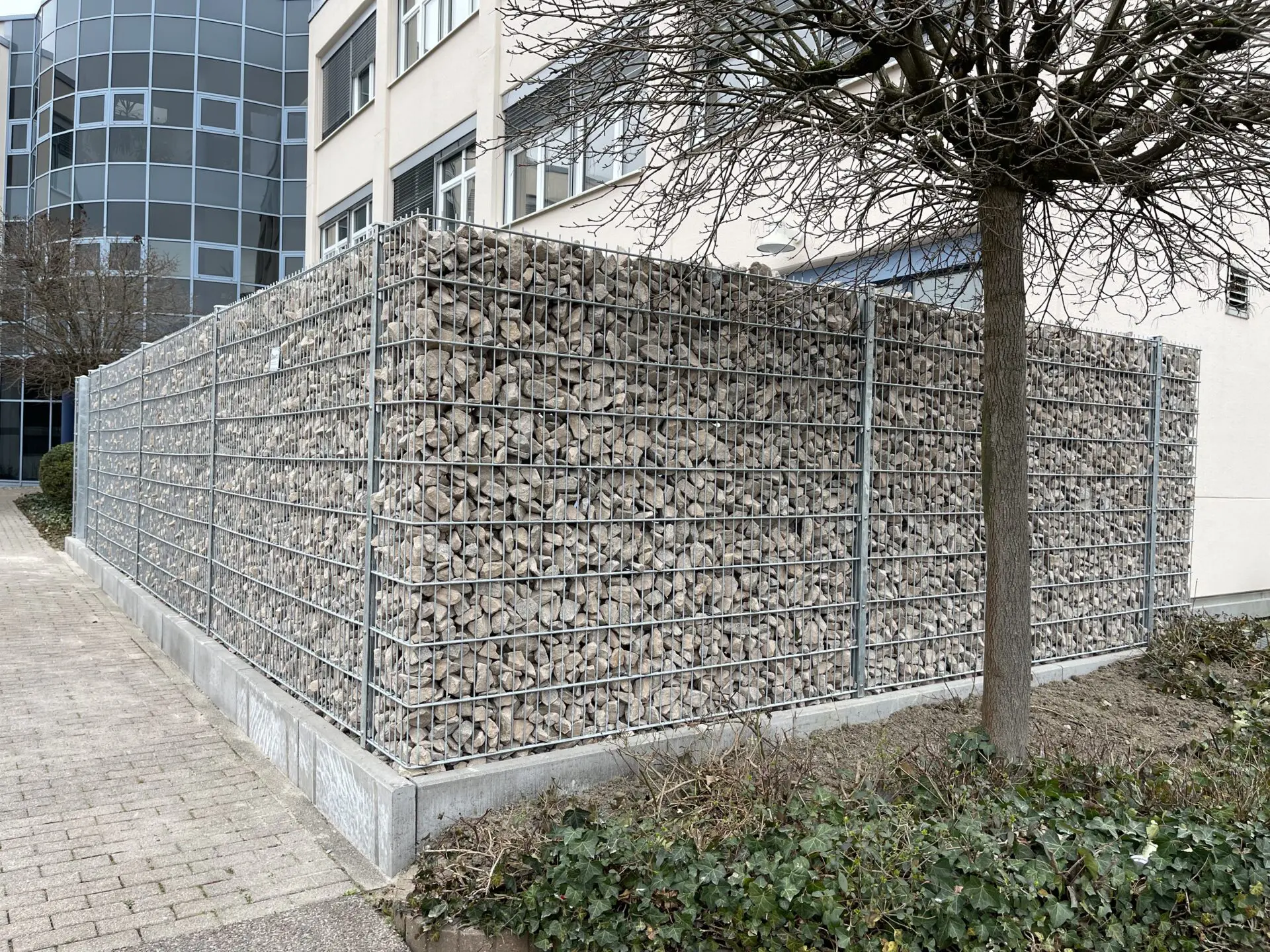 Einfassung mit Gabionenwand 1,80m hoch, gefüllt mit Granitschroppen